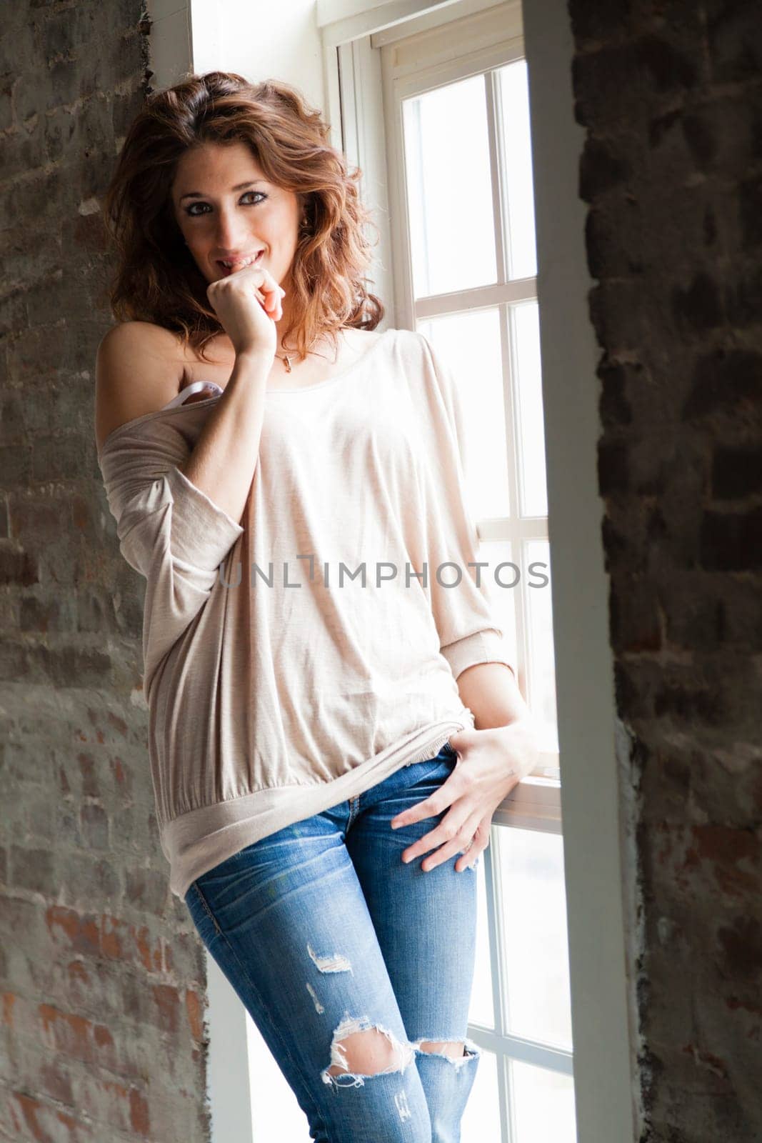 Attractive young woman standing by the window