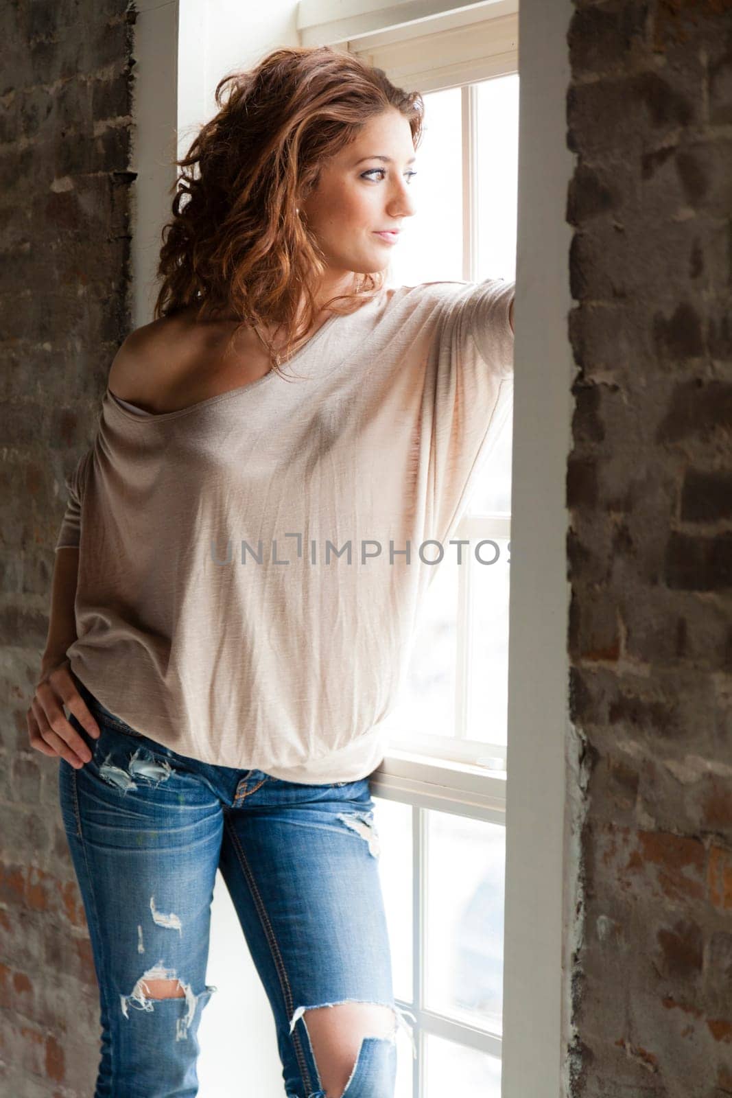 Attractive young woman standing by the window