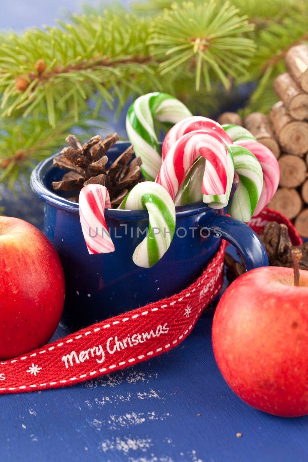 Colorful candy canes in a small enamel cup