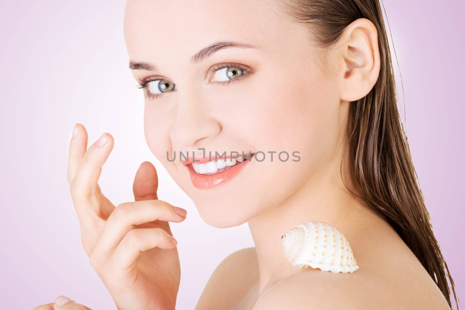 beautiful face of spa woman with healthy clean skin and sea shell.