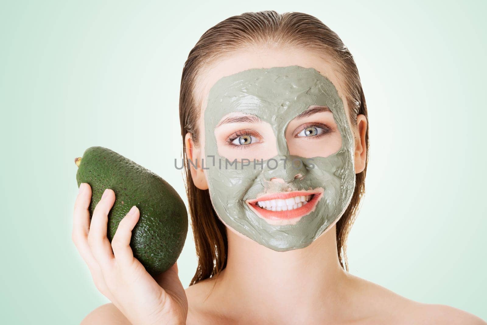 beautiful woman with green avocado clay facial mask
