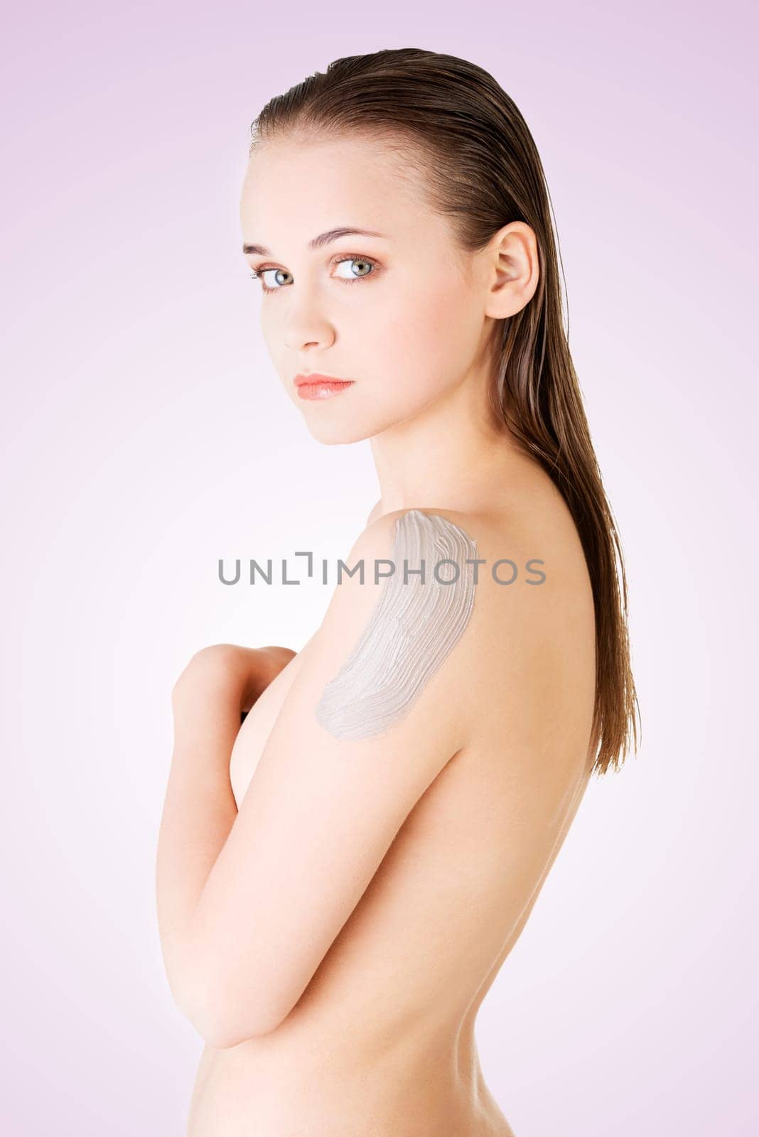 beautiful face of spa woman with clean skin and clay mask on arm.