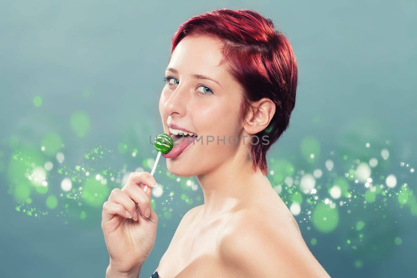 Red-haired Beautiful Woman Licks Green Lollipop