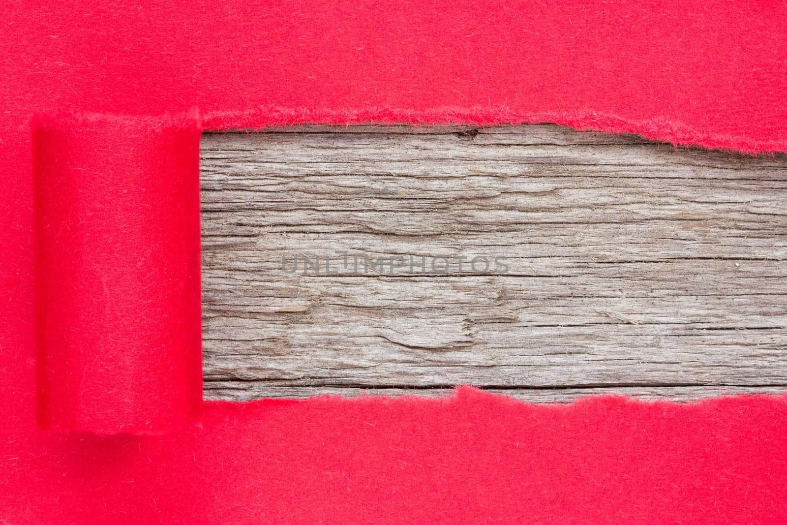 Red paper torn to reveal wooden panel for copy space.