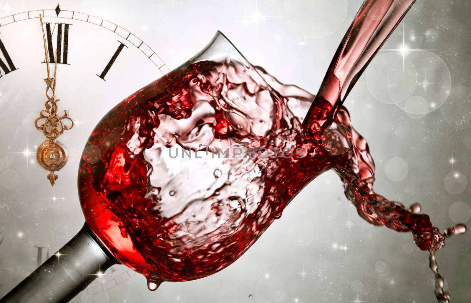 Red wine against fireworks, holiday lights and clock close to midnight