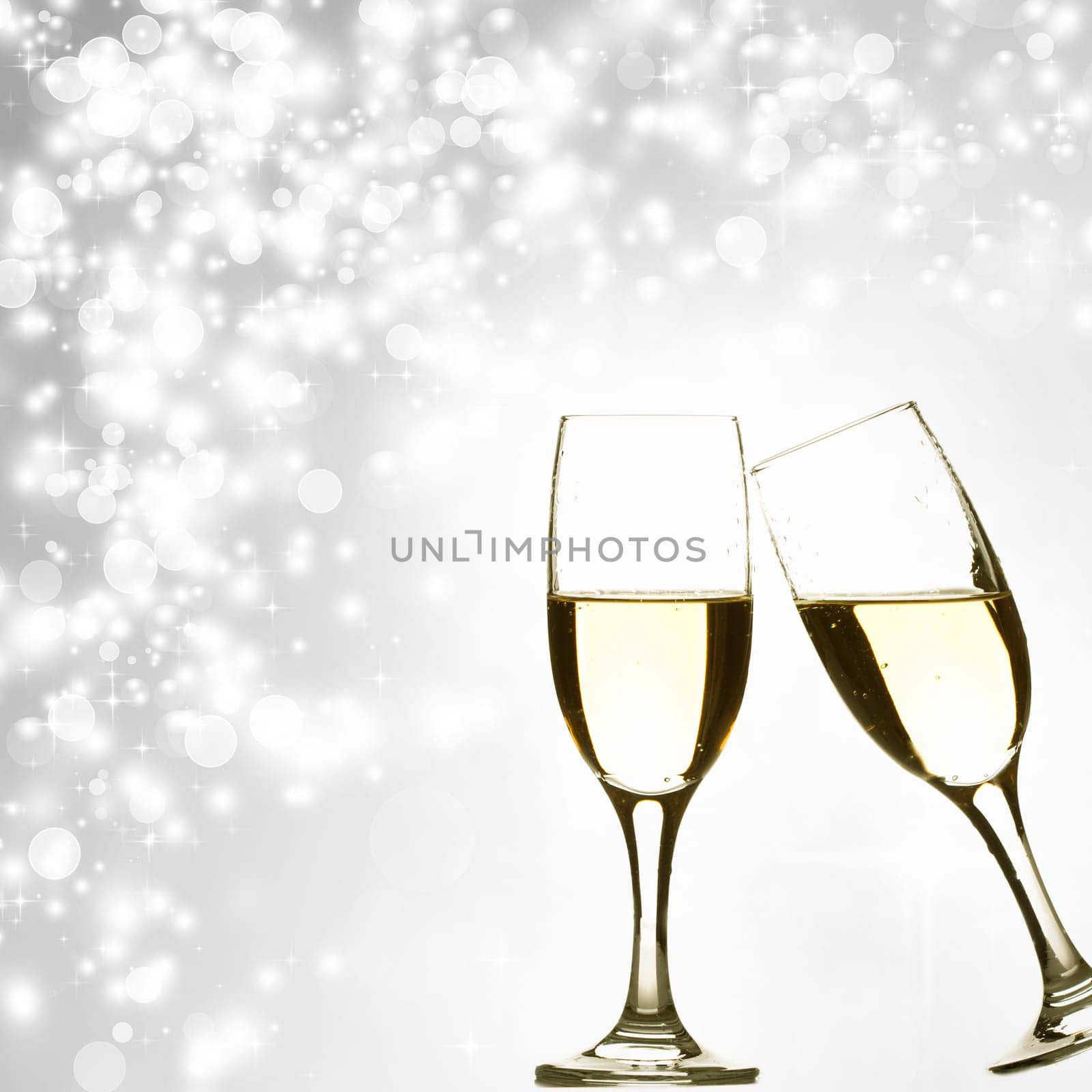 Glasses with champagne against holiday lights