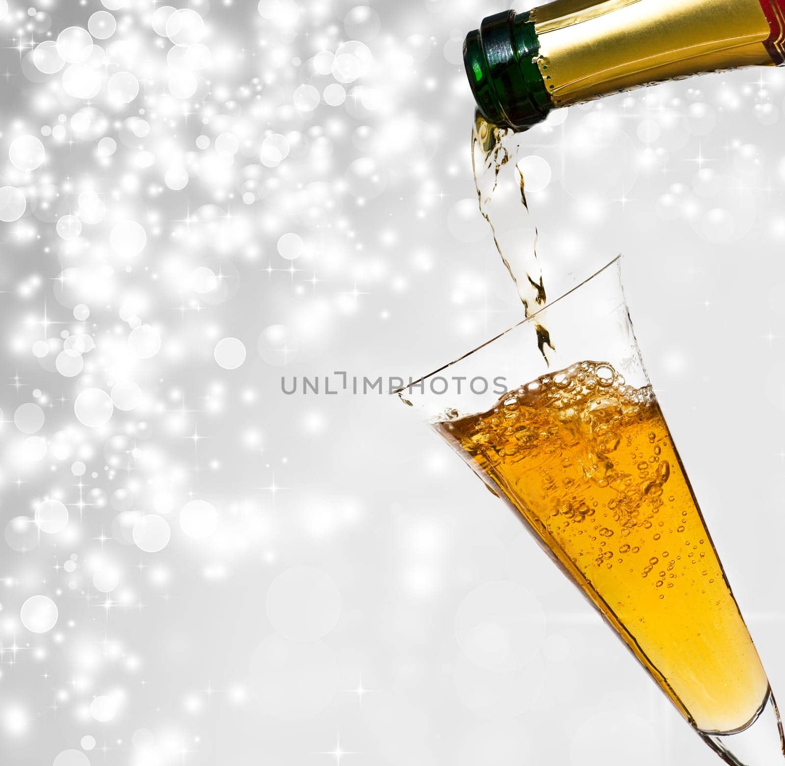 Pouring champagne against festive holiday lights