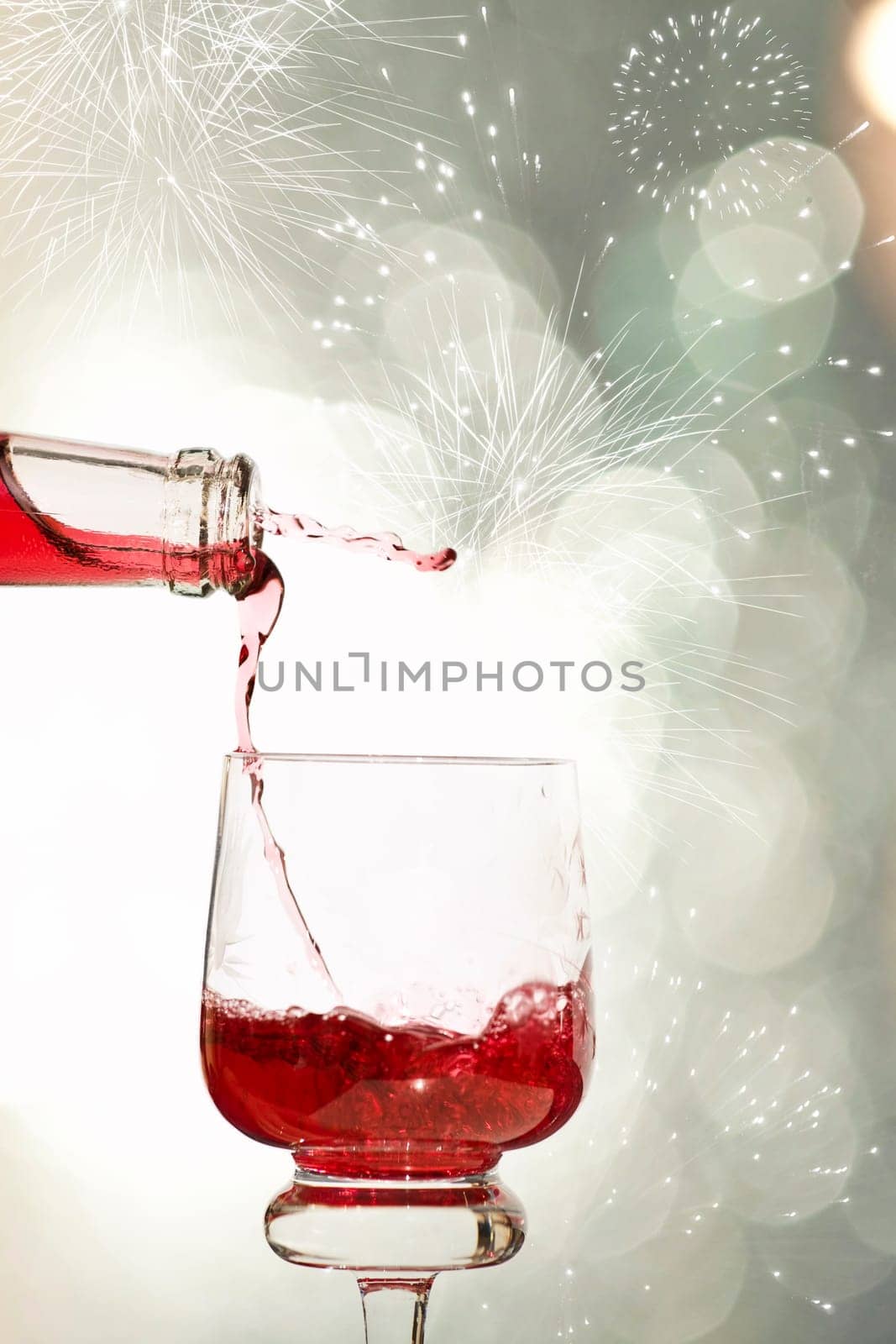 Pouring red wine against festive holiday lights