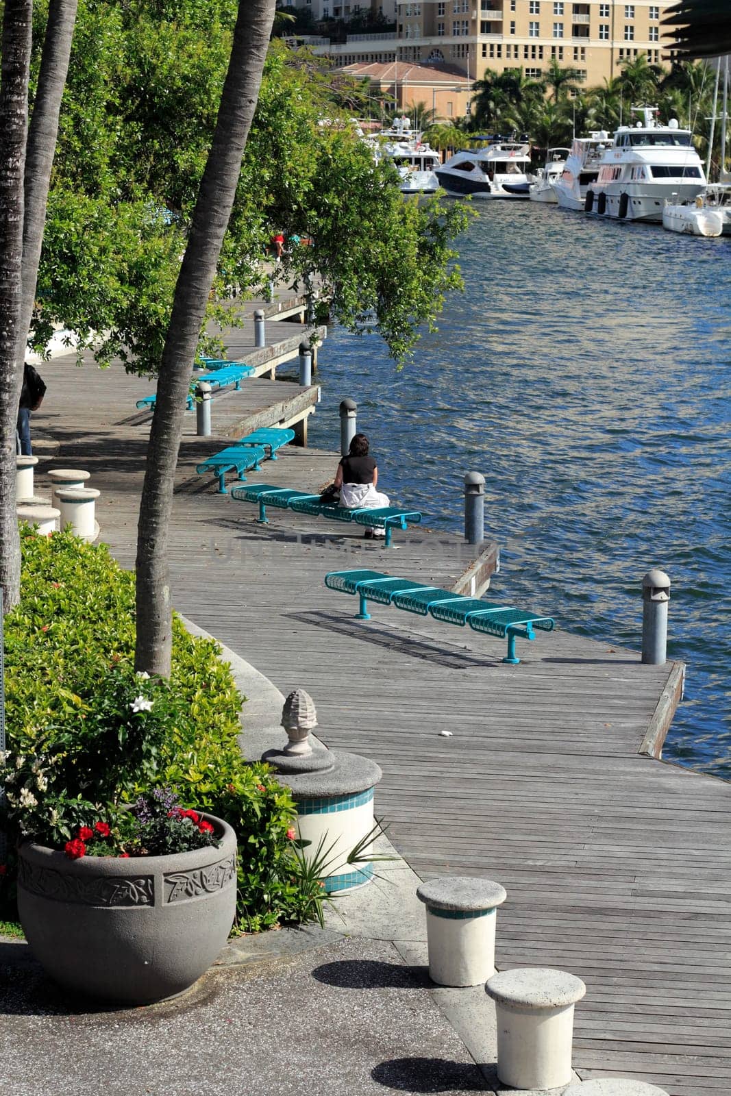 FORT LAUDERDALE, FLORIDA - FEBRUARY 3: Boats moored and people relaxing and walking along the wooden walkway at the Riverwalk beside the New River on February 3, 2013 in Ft Lauderdale, Florida.