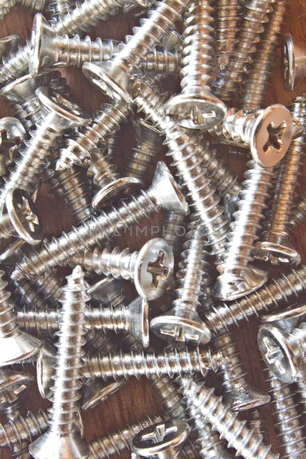 close up steel screws on wooden background