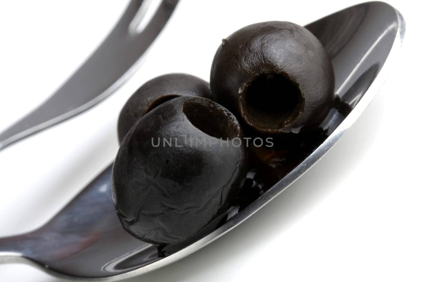 black olives on a metal spoon