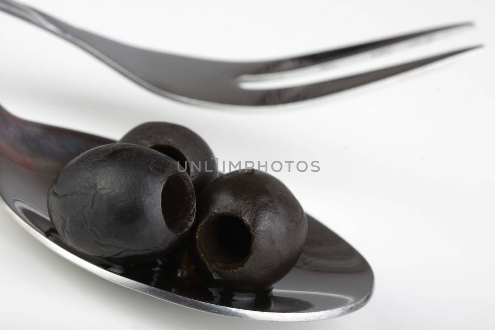 black olives on a metal spoon