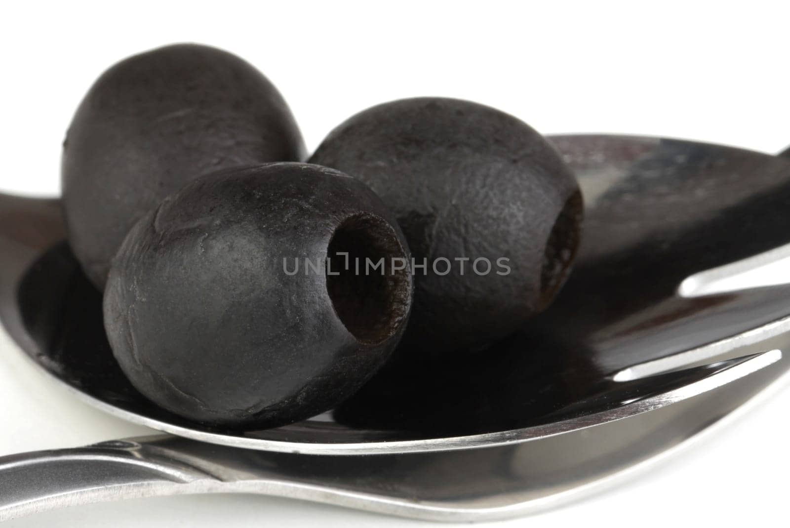 black olives on a metal spoon