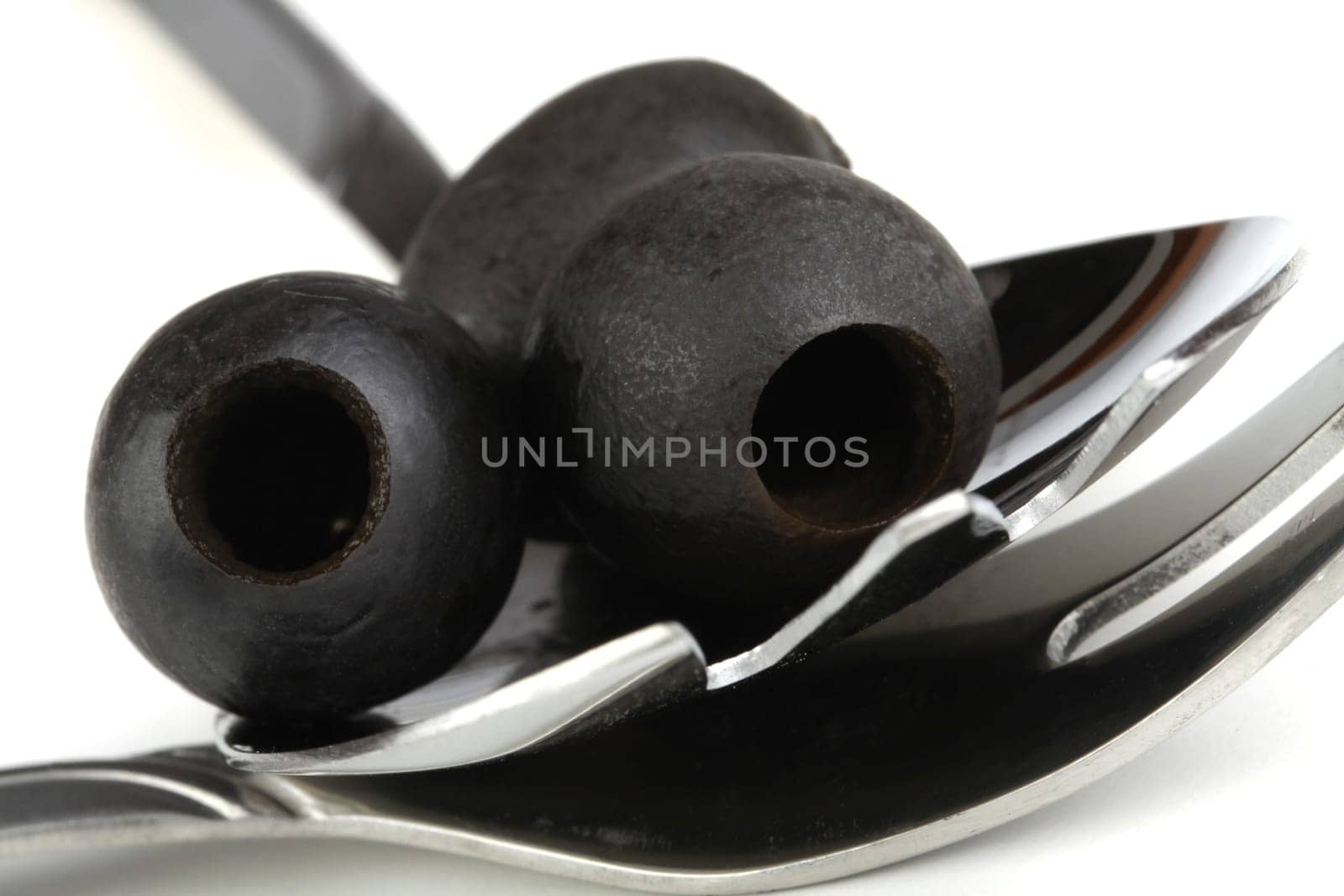 black olives on a metal spoon