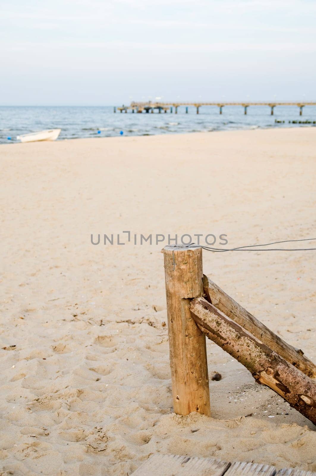flat fence post with tensioned wire on the sandy beach near the city of Bansin / Usedom / Germany in summer