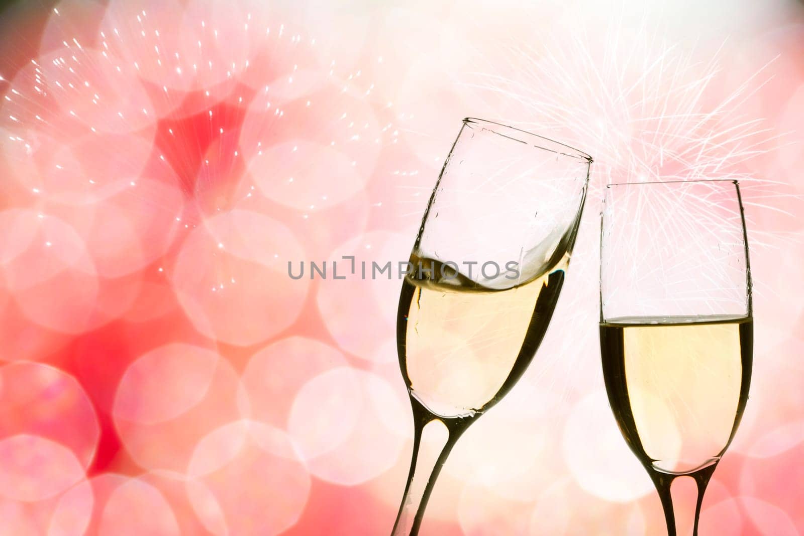 Glasses with champagne against fireworks and clock close to midnight
