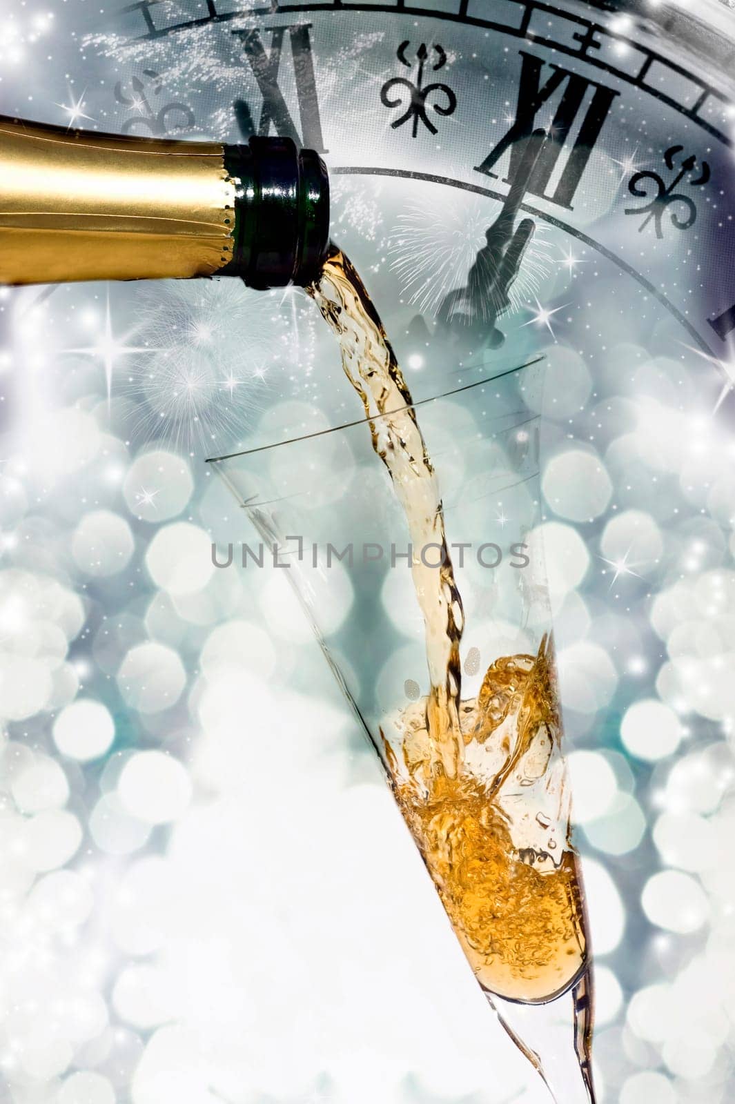 Pouring champagne against holiday lights and clock close to midnight