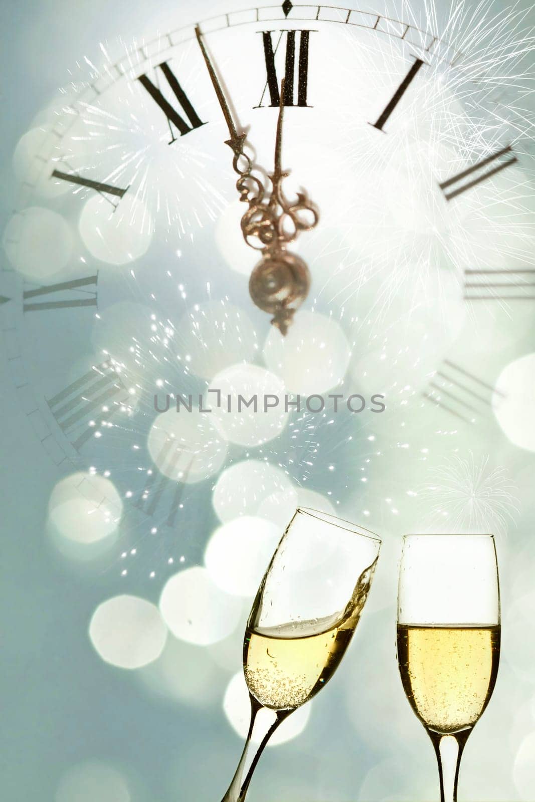 Glasses with champagne against holiday lights and clock close to midnight