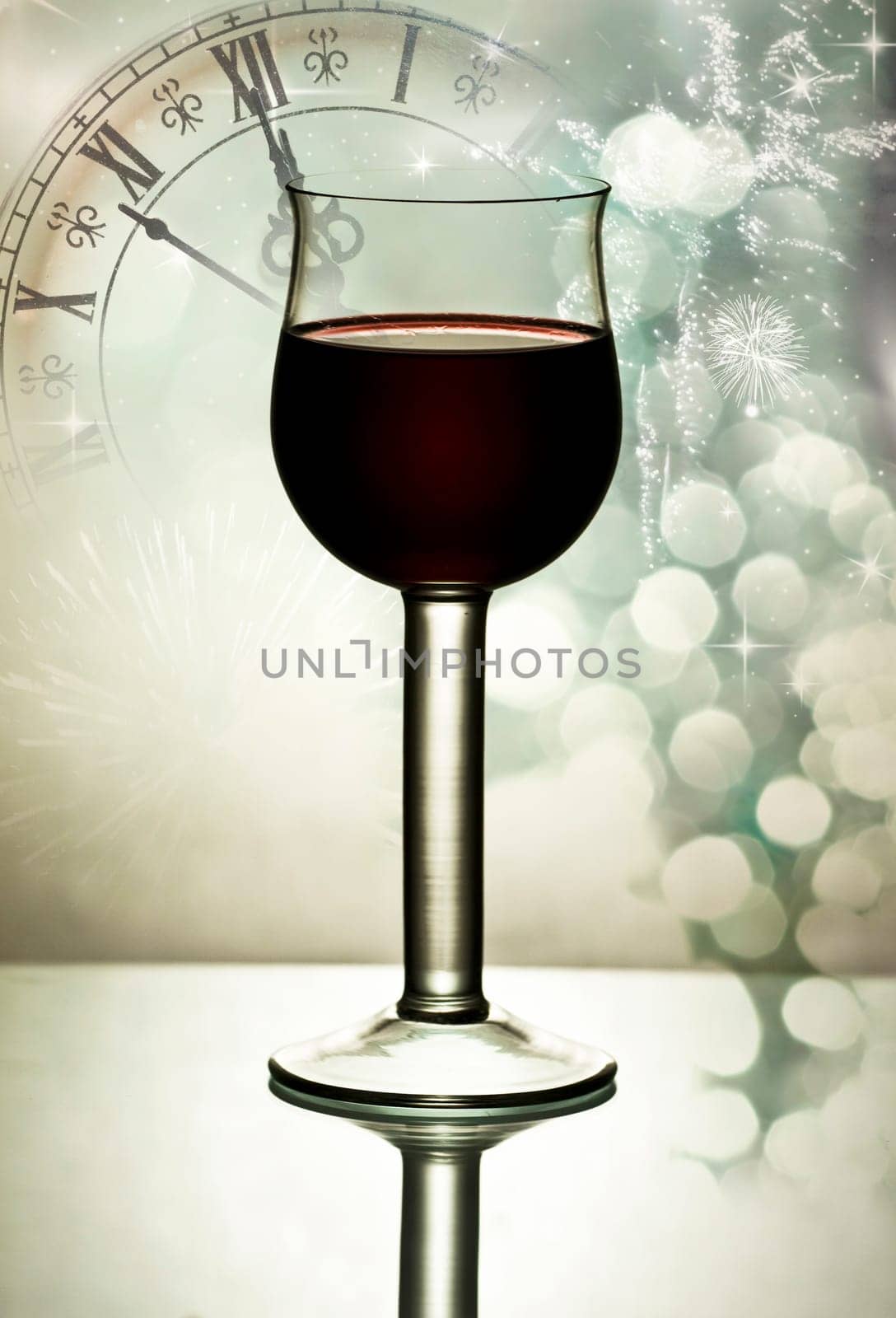 Red wine against fireworks, holiday lights and clock close to midnight