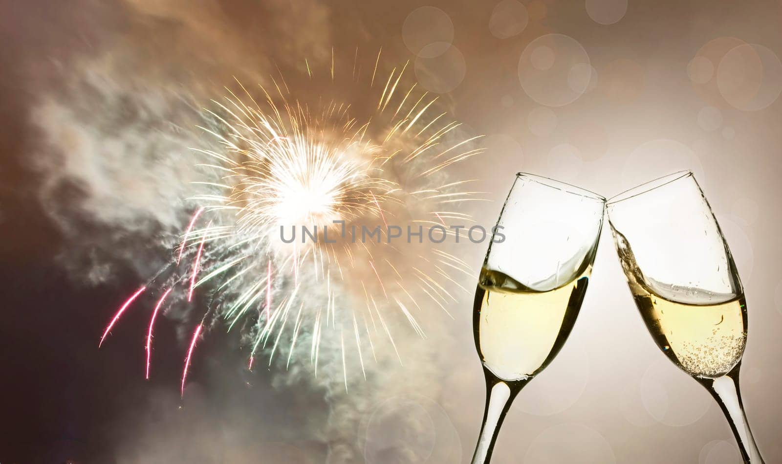 Glasses with champagne against fireworks and holiday lights