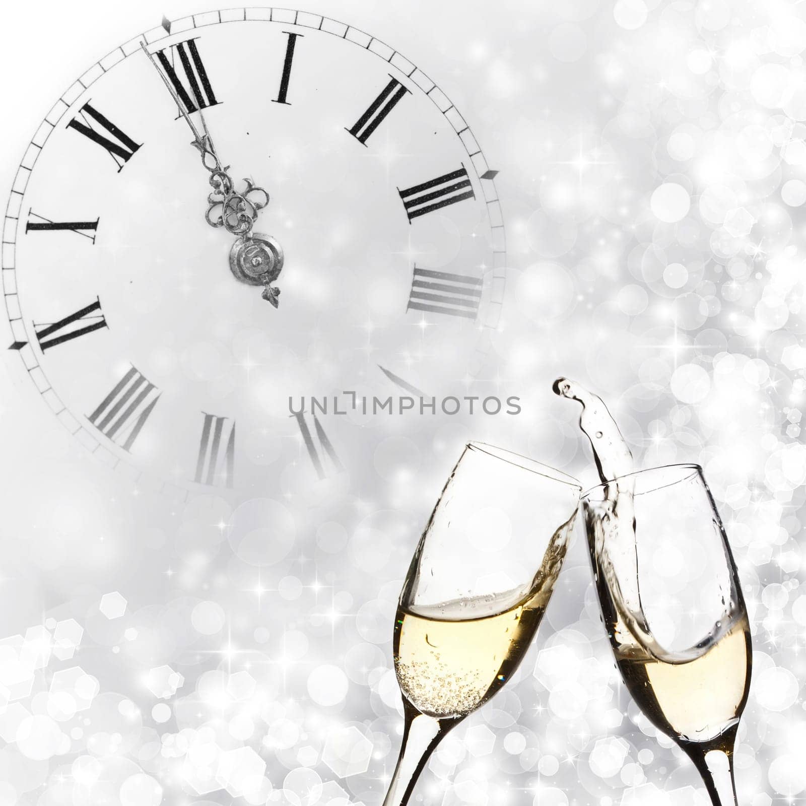 Glasses with champagne against holiday lights and clock close to midnight