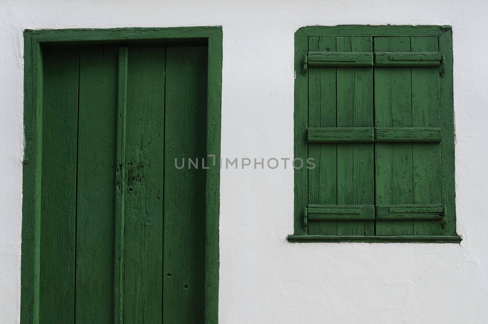 Wooden door and window shutter. Old house white wall background texture.