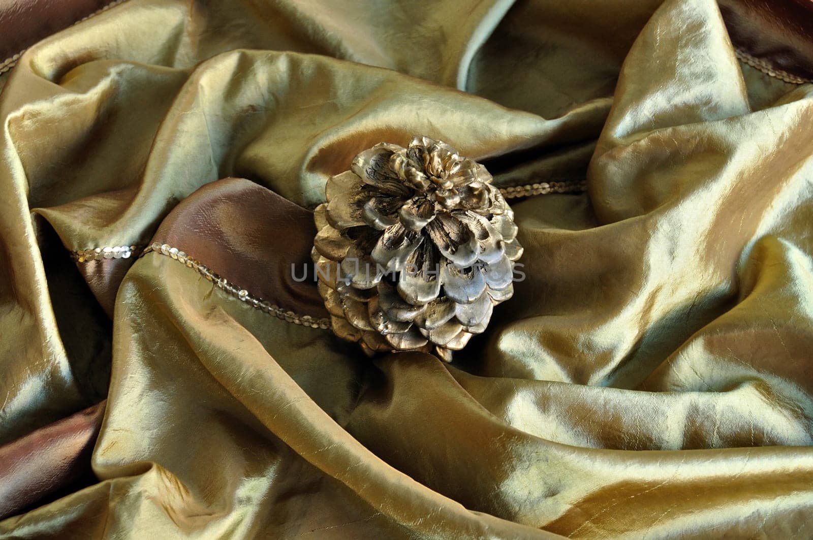 Golden cone on silk texture. Christmas decoration seasonal background.
