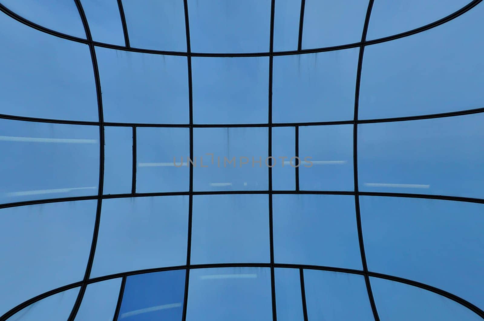 Distorted glass facade of modern building. Abstract architectural detail.