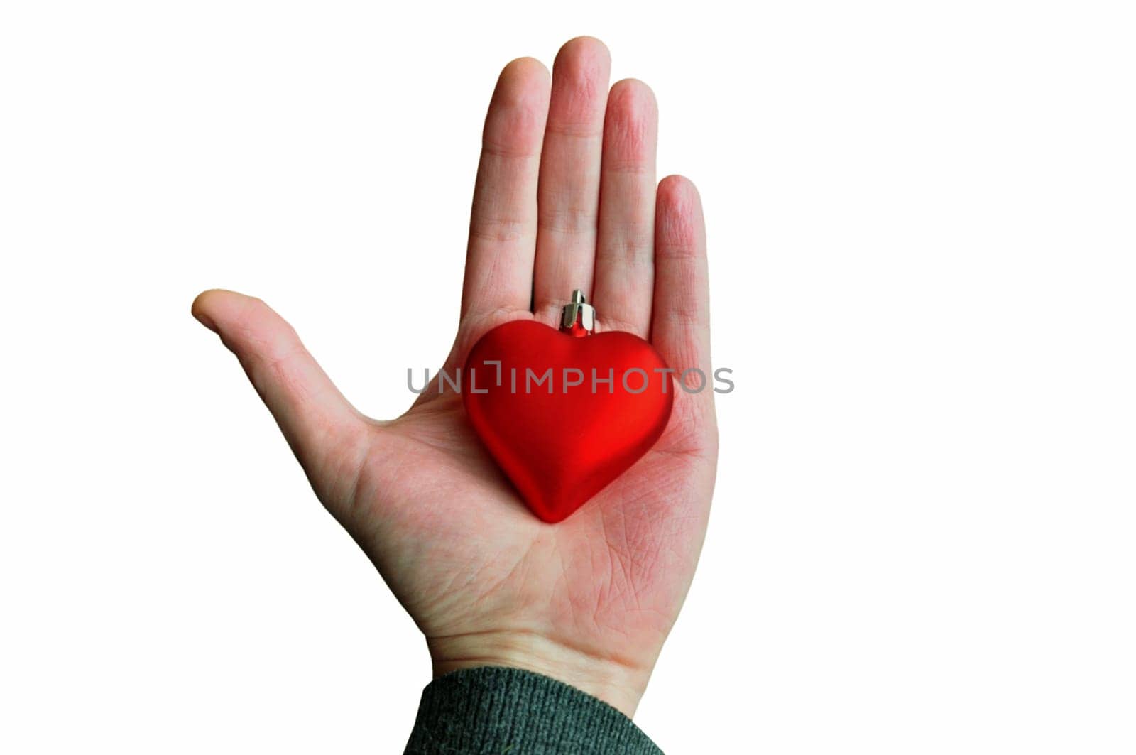 Hand holding red heart bauble. Christmas love concept seasonal background.