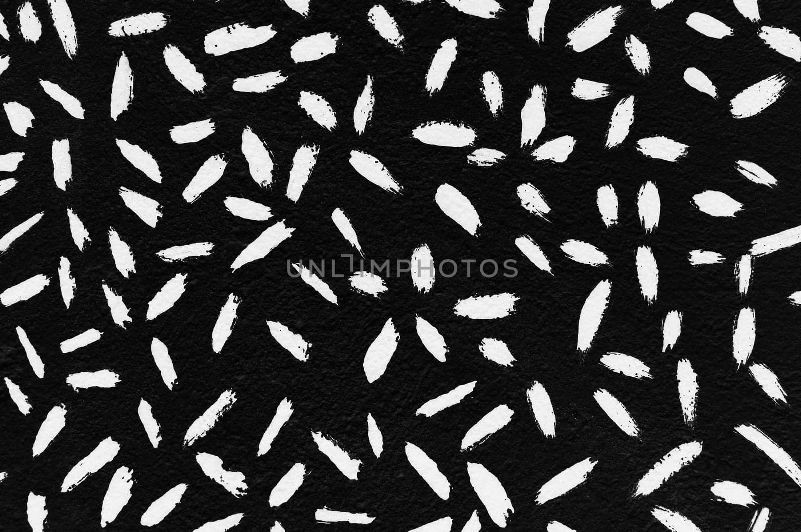 White paint strokes abstract lines pattern on black textured surface.