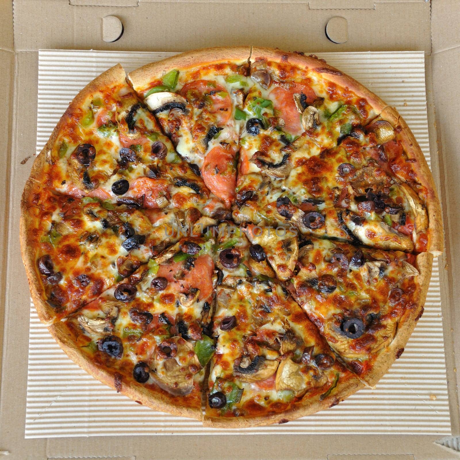 Pizza with pepperoni, mushrooms, pepper, and olives. Italian fast food background.