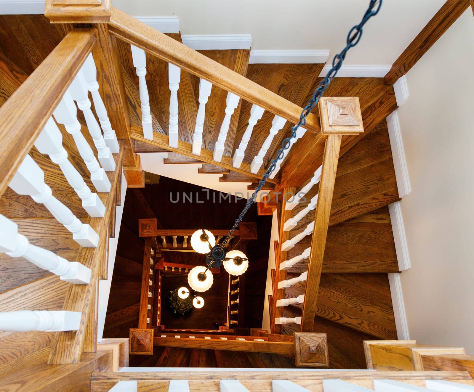 A view from above at a spiral staircase with chandeliers