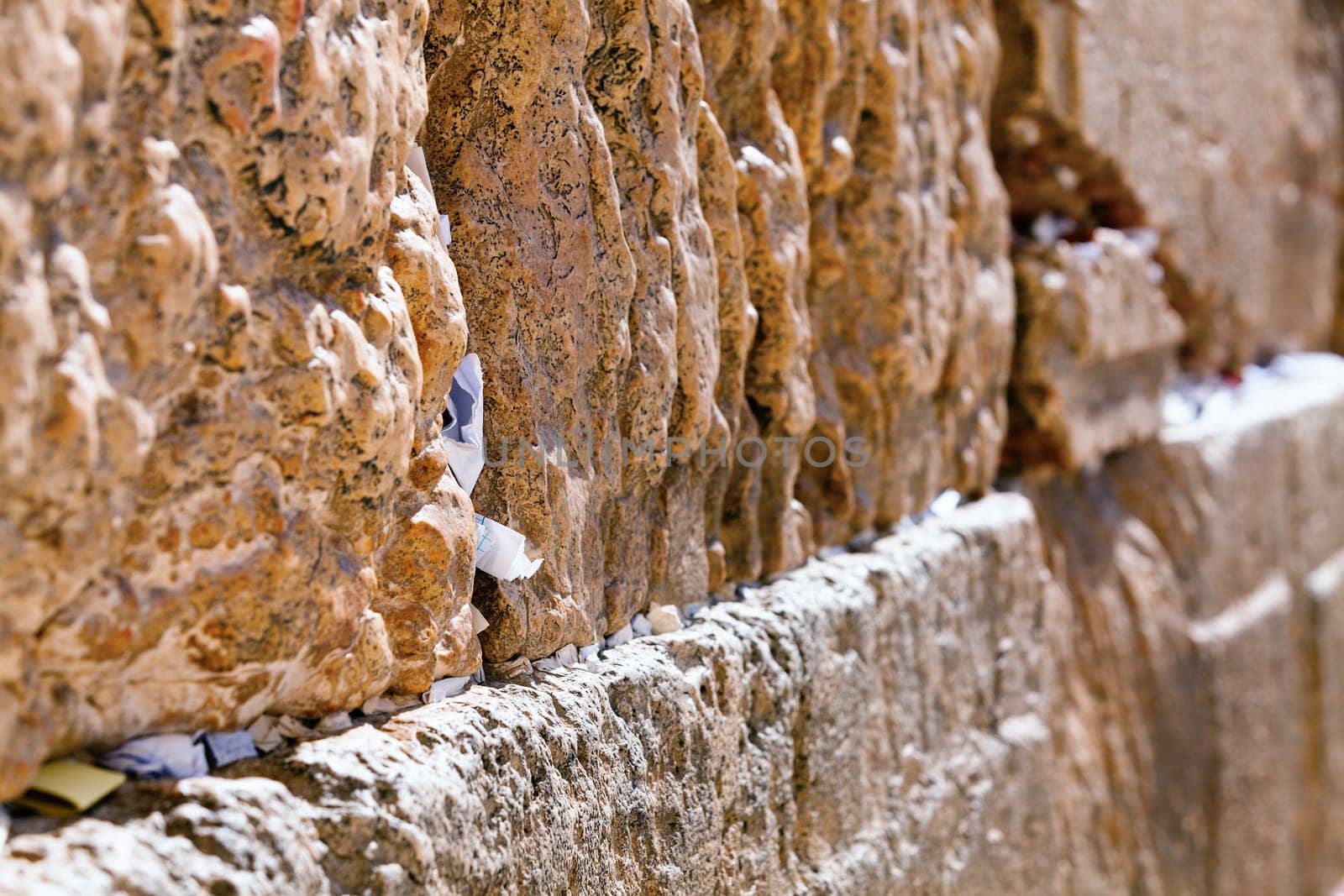 Closeup of notes people leave for God between the stones of the Western Wall in Jerusalem