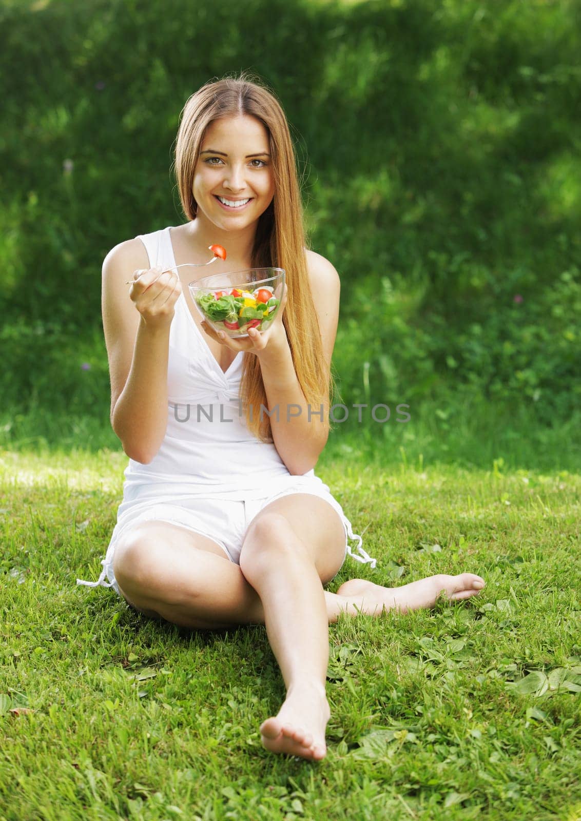 Portrait of happy beautiful young woman eating vegetable salad