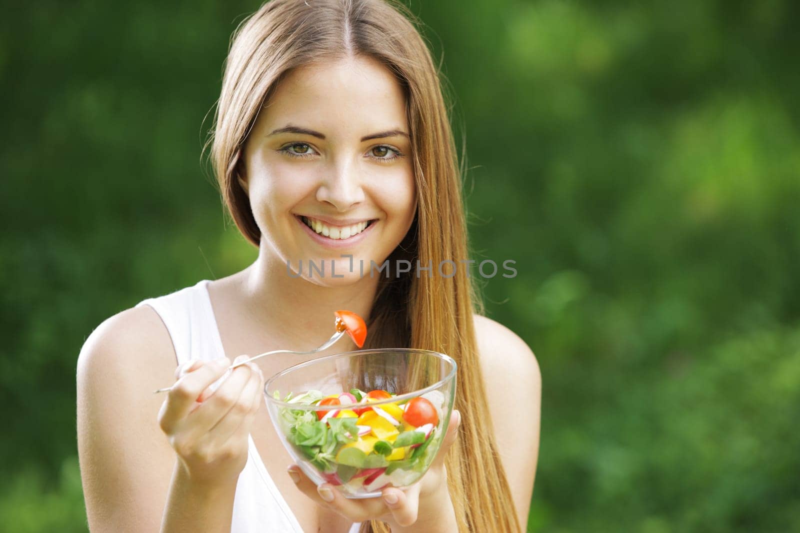 Portrait of young happy woman eating salad