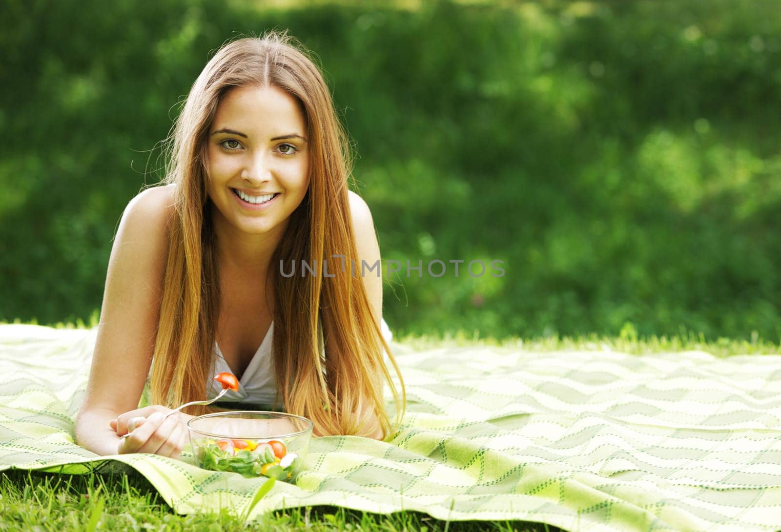 Portrait of happy beautiful young woman eating vegetable salad