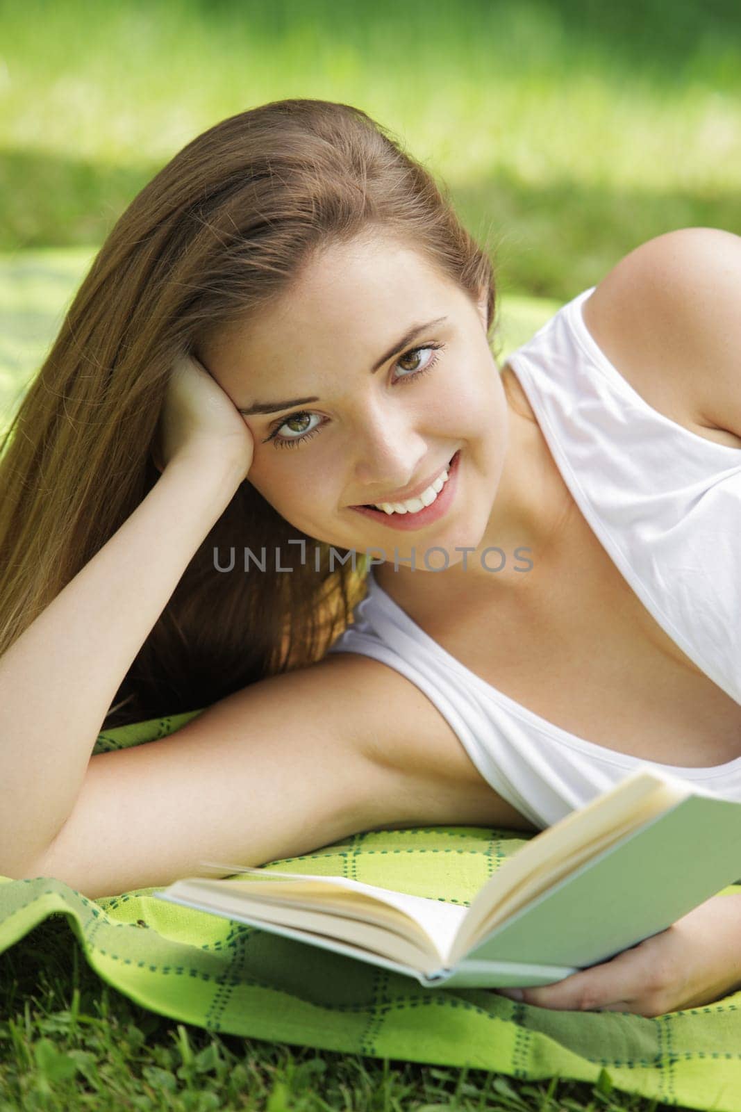 Closeup of a beautiful young woman reading book at park