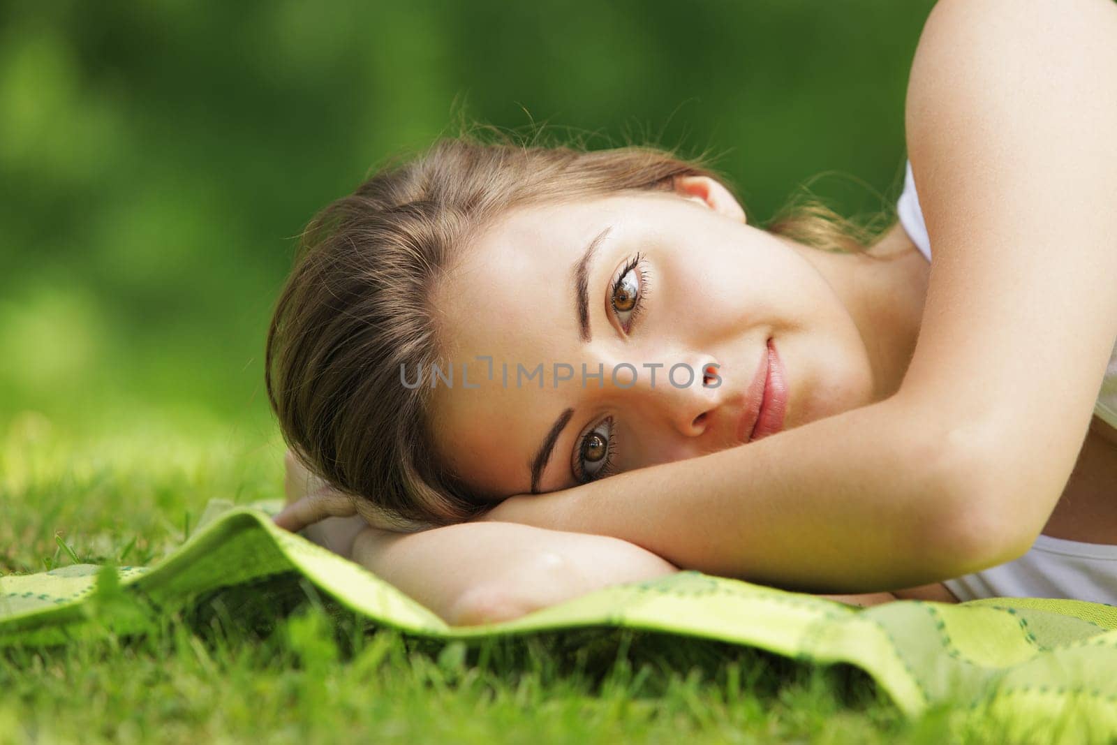 Young beautiful woman laying on the grass, close up
