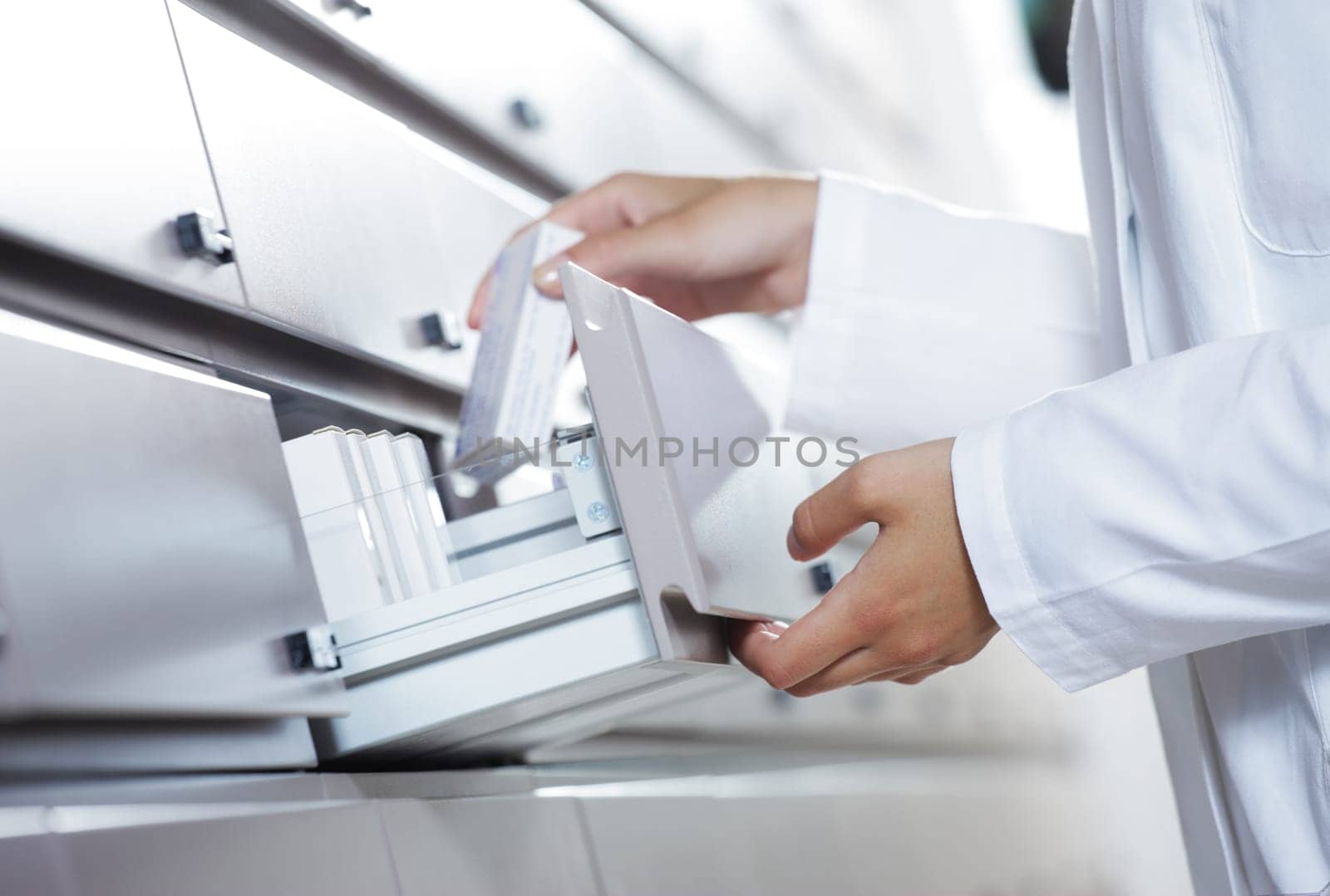 Close up view of pharmacist taking medicine from drawer