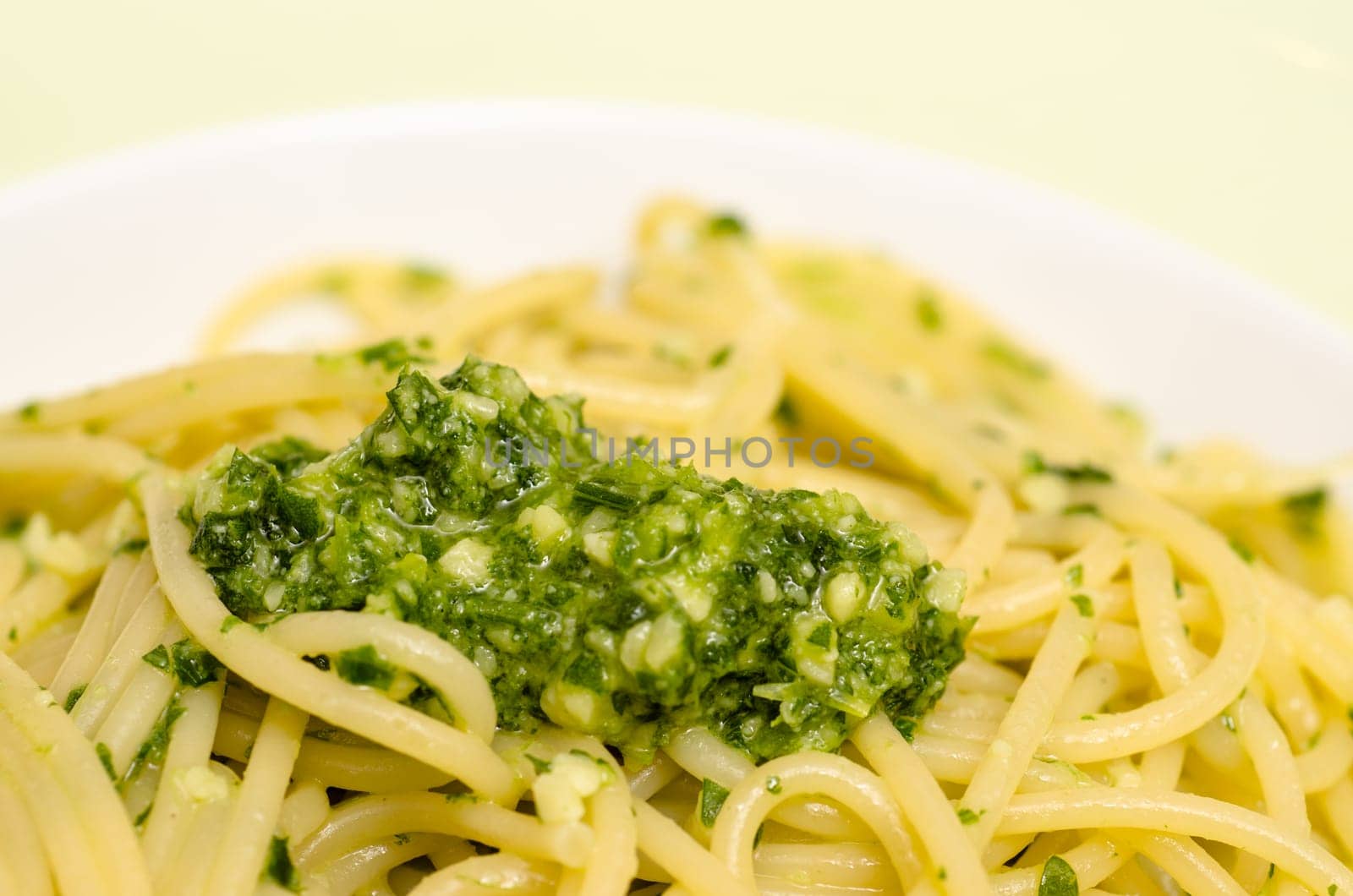 Close-up of green ruccola pesto with spaghetti