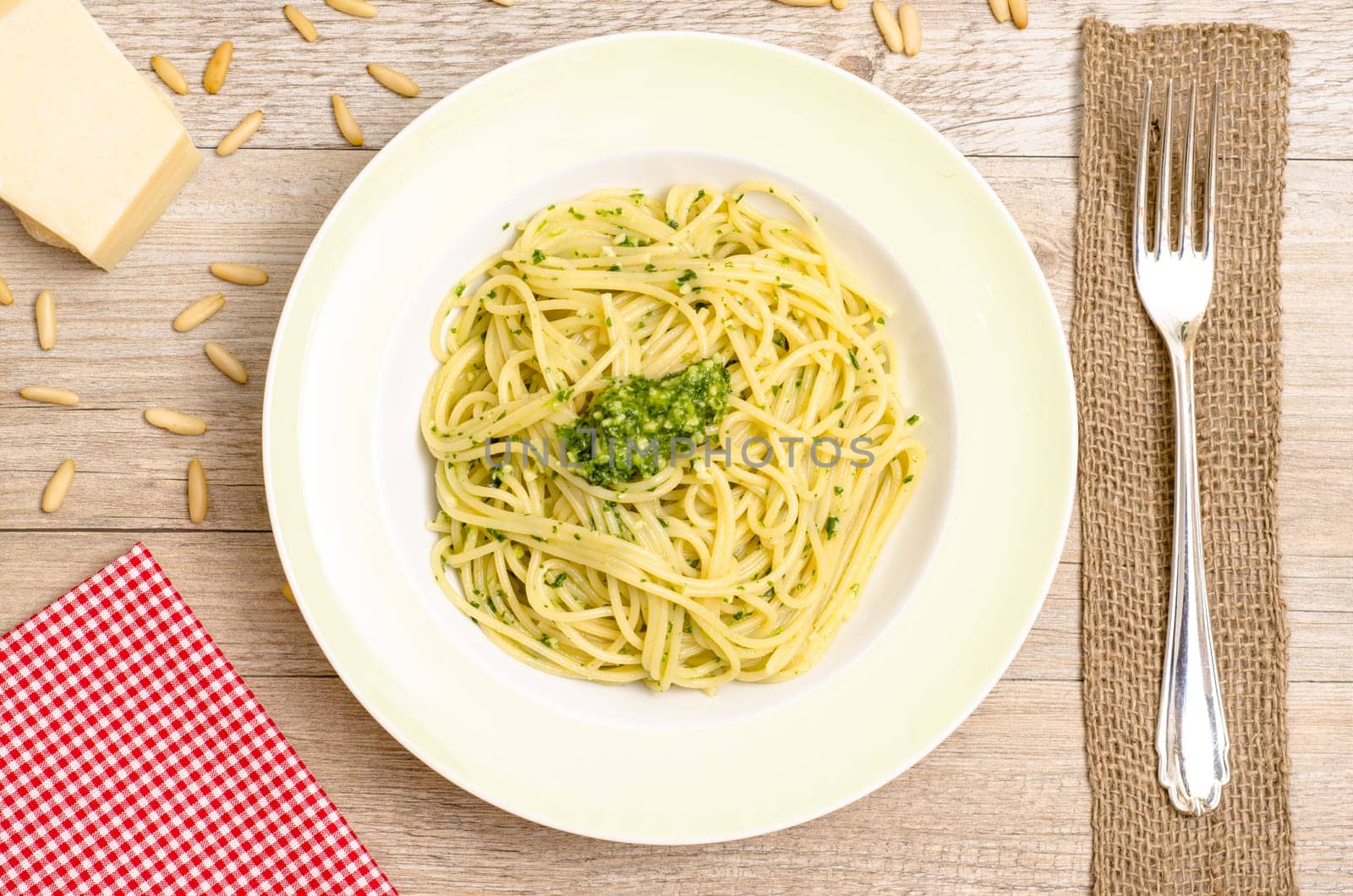 Spaghetti with pesto on a plate with a fork