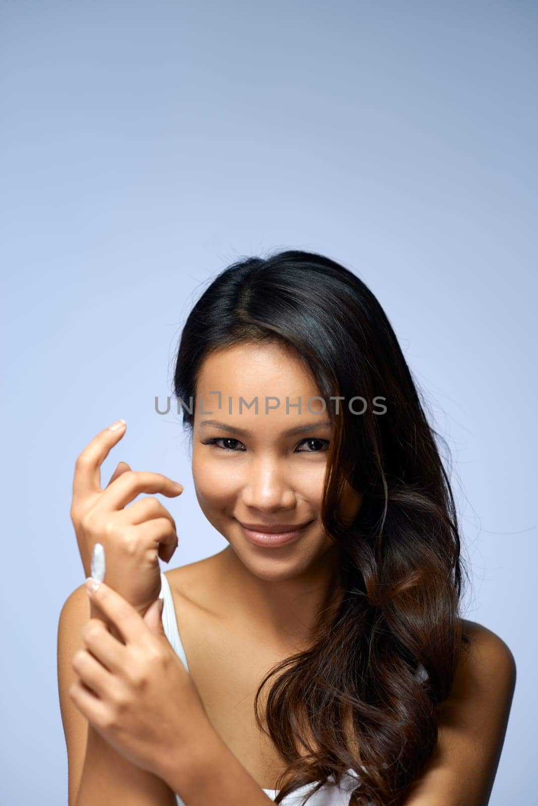 Young people and body care with portrait of happy asian girl smiling, applying moisturizer for hand skin therapy