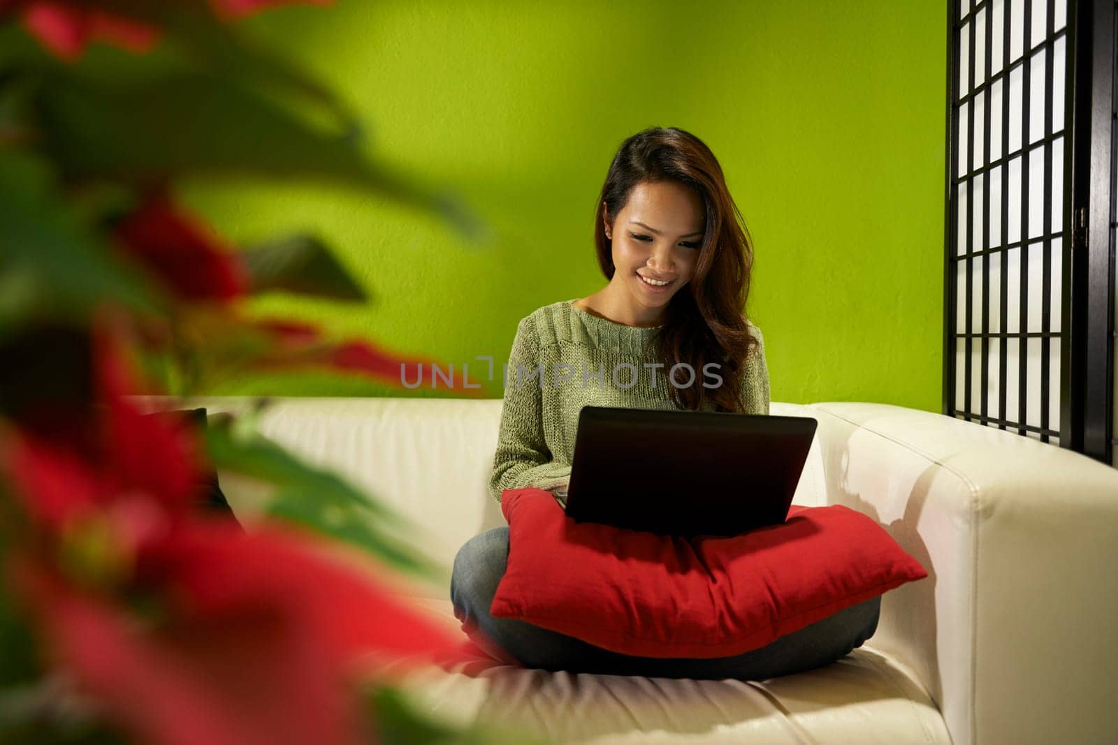Young people and technology, happy Asian woman typing on laptop pc, beautiful female student using computer sitting on couch at home