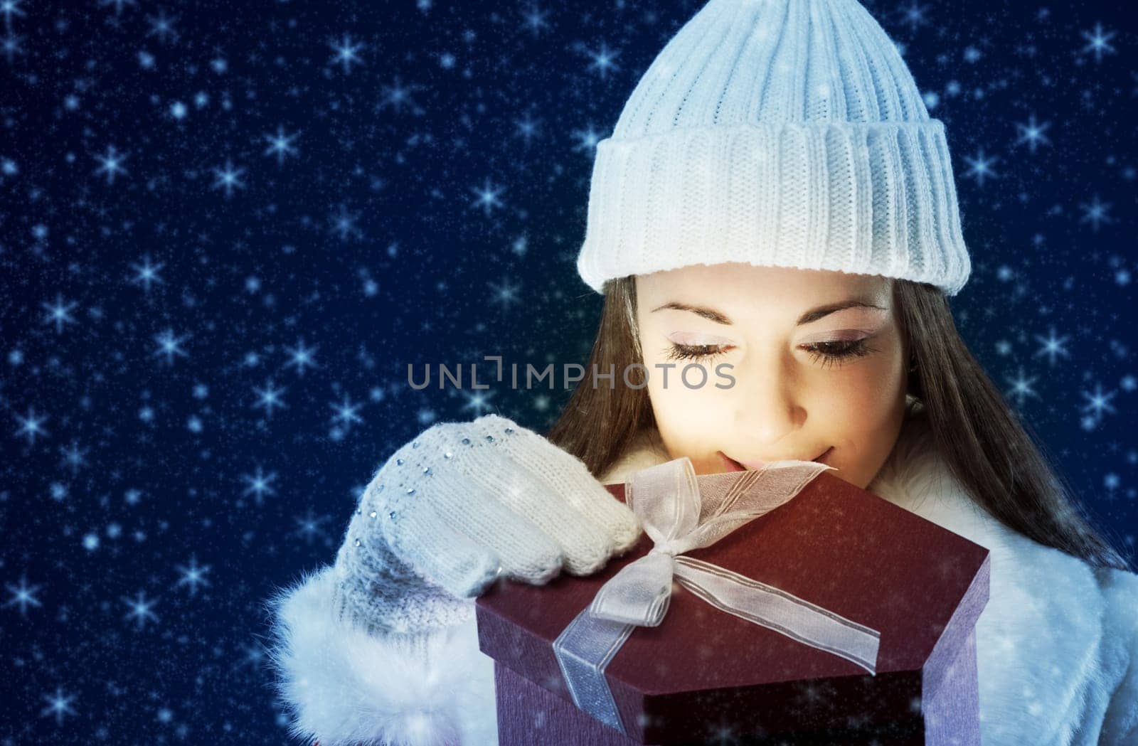 Happy young woman opening Christmas presents, copy space