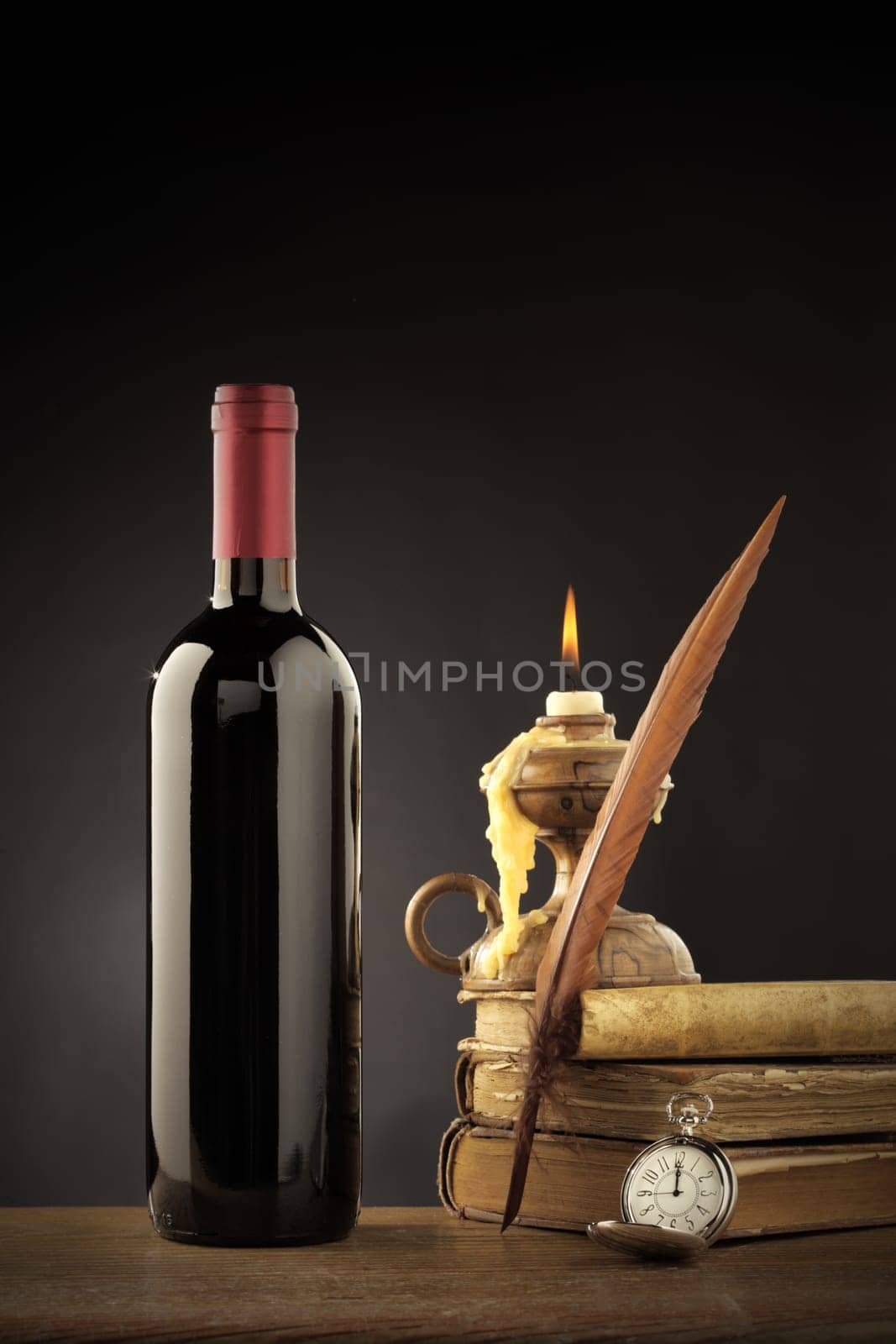 Wine bottle with old books and candle
