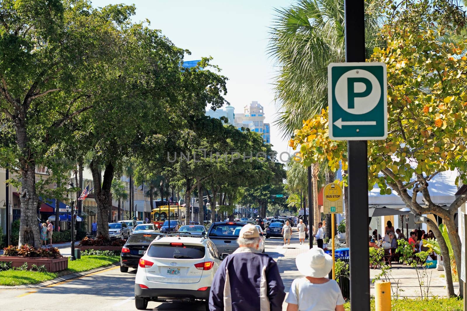 FORT LAUDERDALE, FLORIDA - FEBRUARY 3, 2013: Adult pedestrians shopping, walking and dining near downtown in a trendy tree lined retail district on a relaxing sunny winter day.