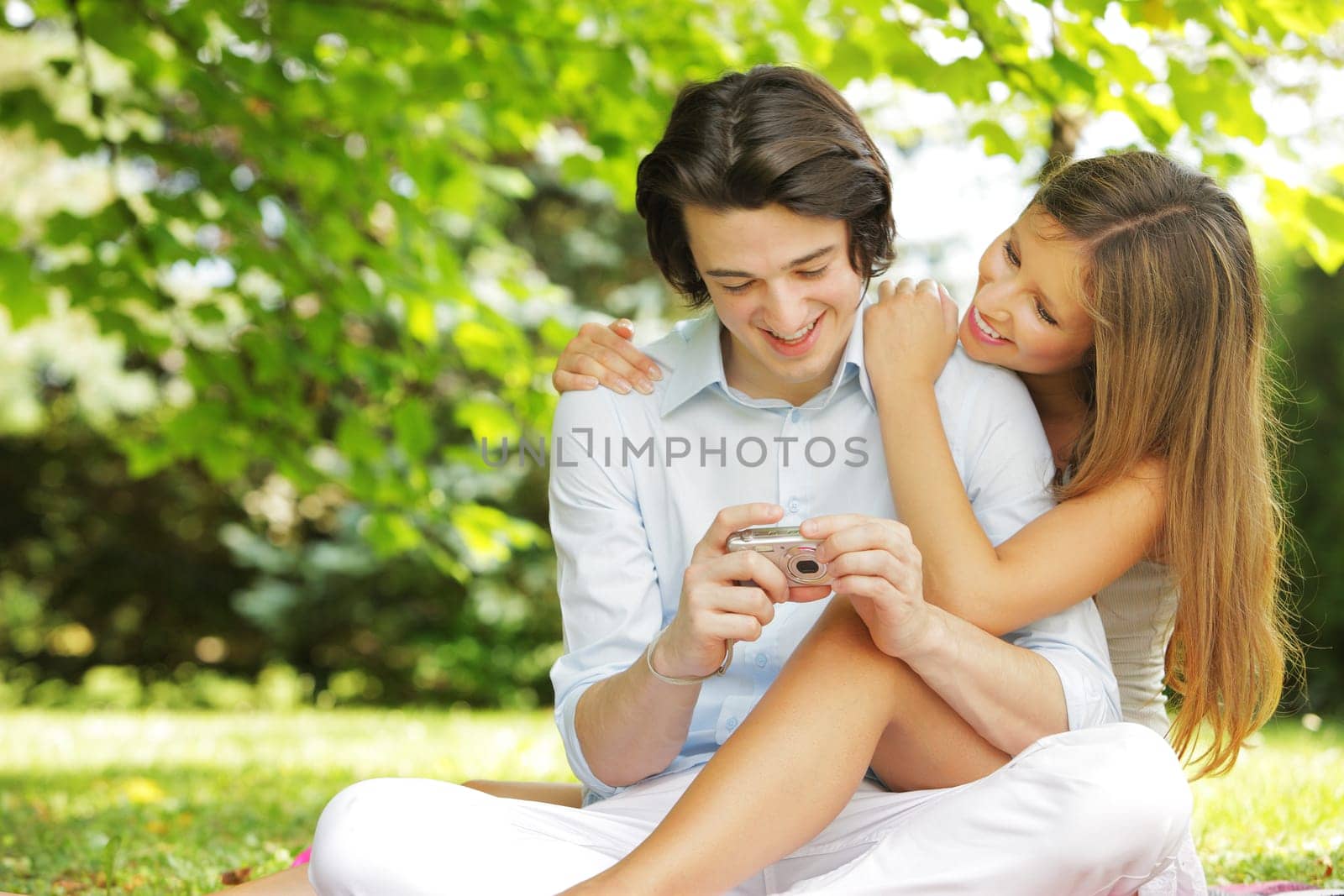 a couple of lovers, view photos on the display of their compact camera