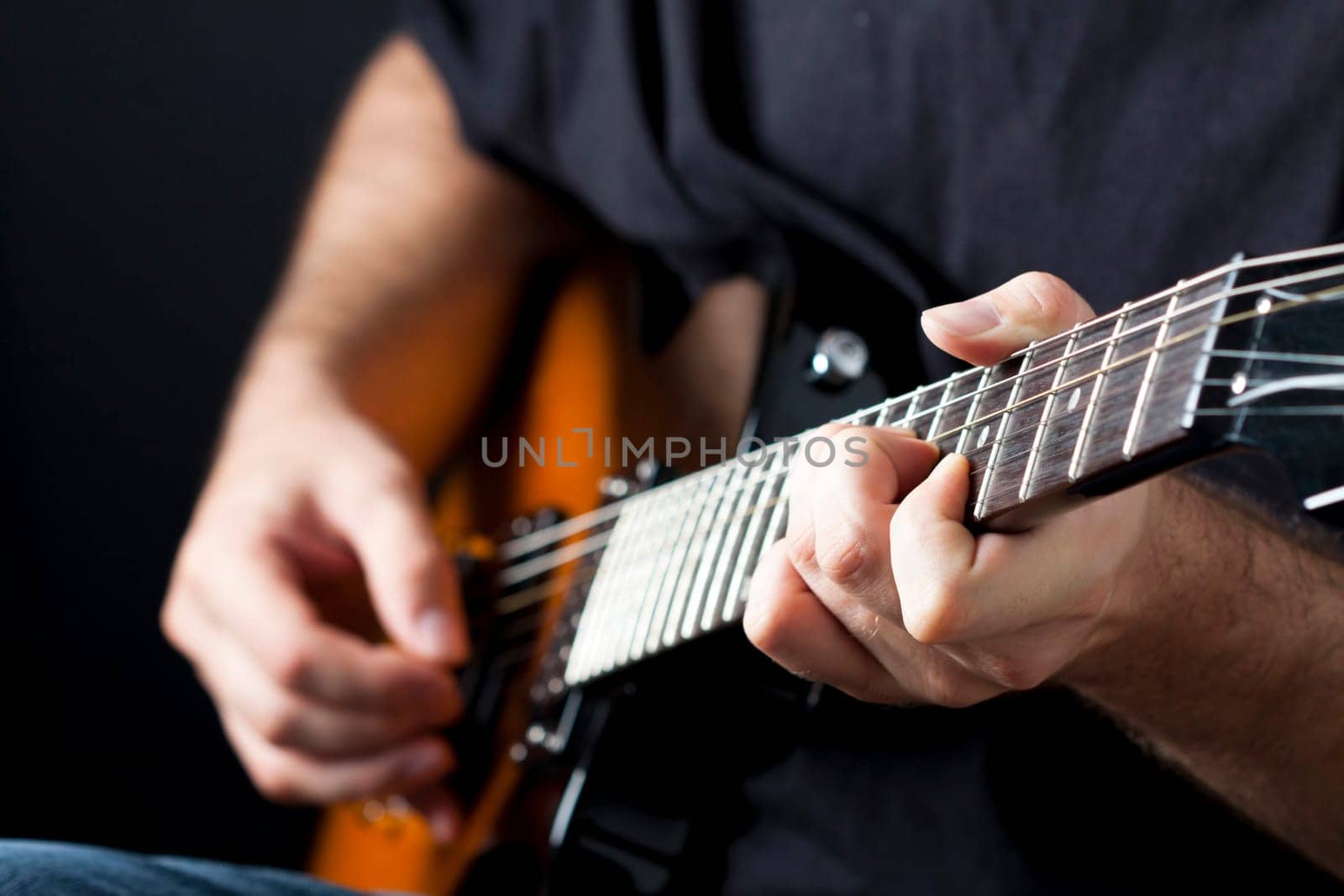 Close up on hands playing on electric guitar