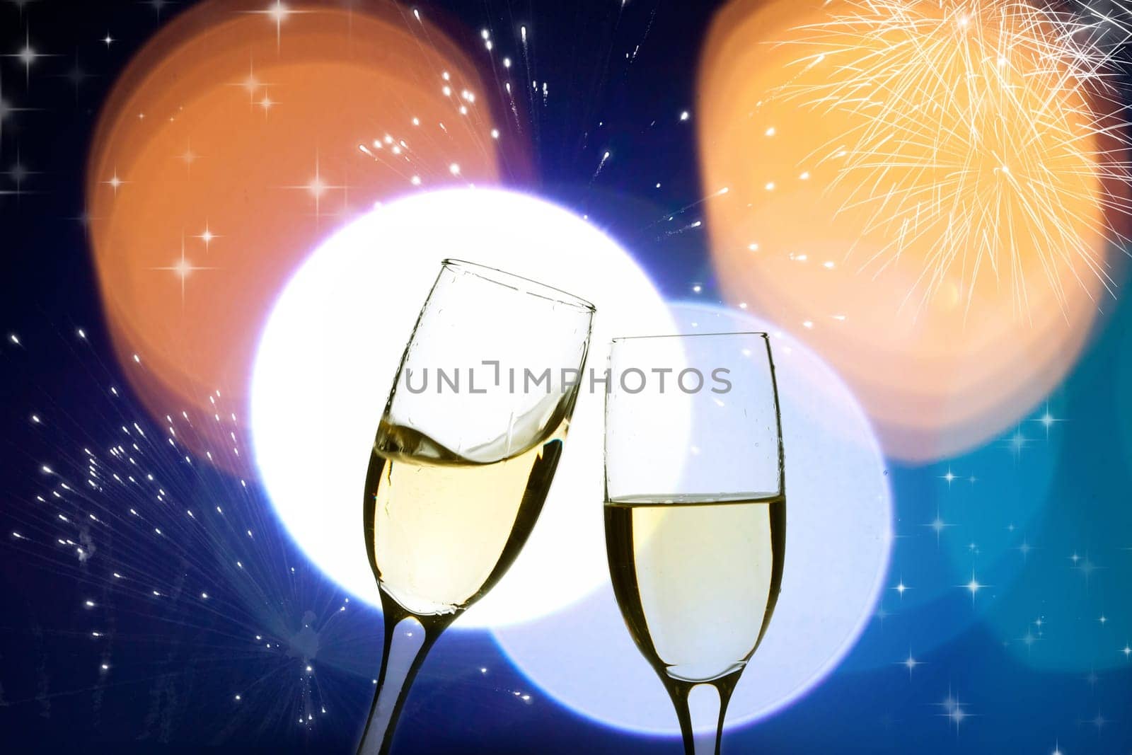 Two glasses of champagne with colorful lights in the background