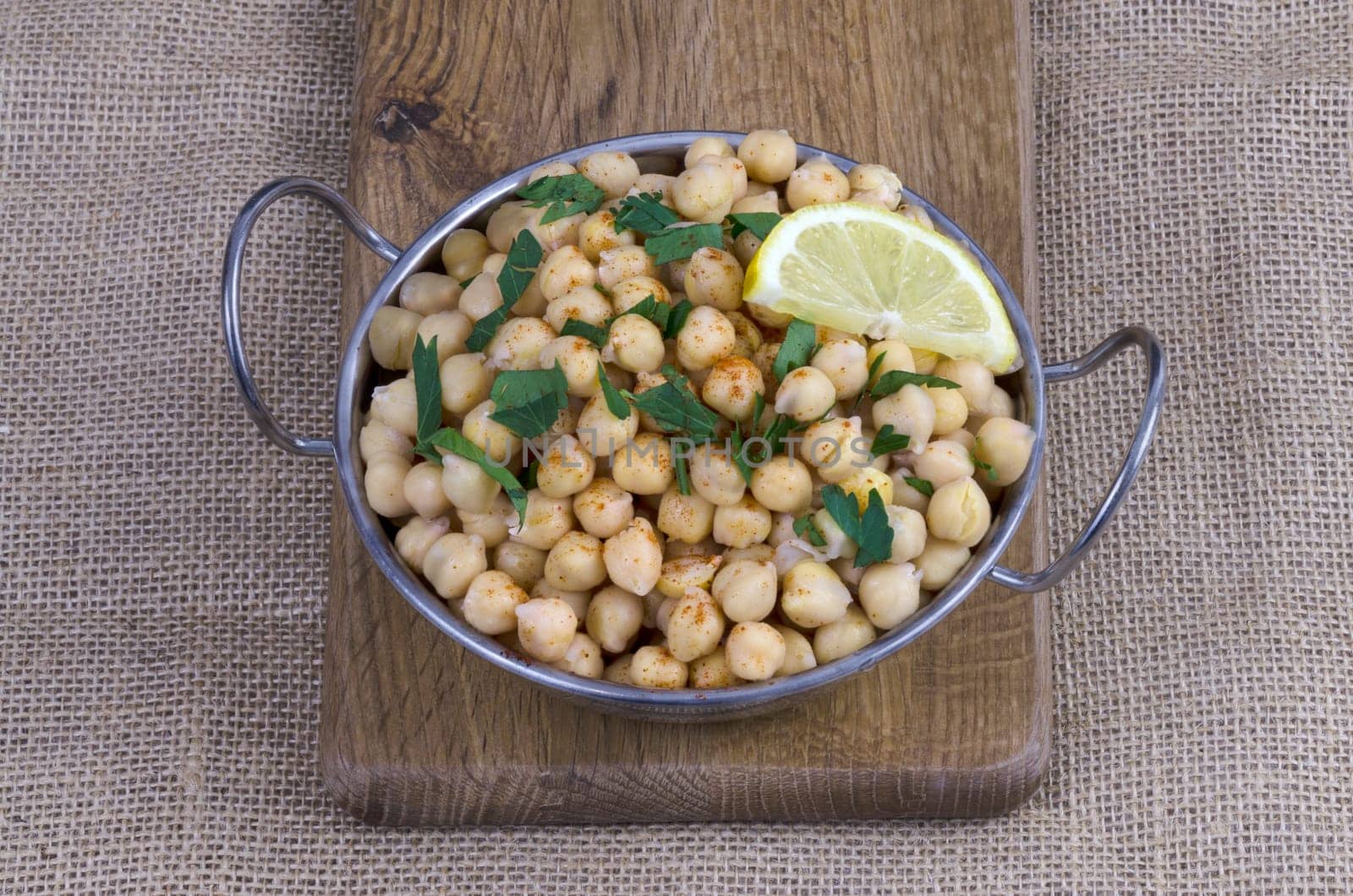 Bowl of cooked chickpeas with parsley and lemon
